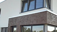 Moderne Wohnhausfassade mit fugenlosem Mikrozement und kontrastierender Oberfläche